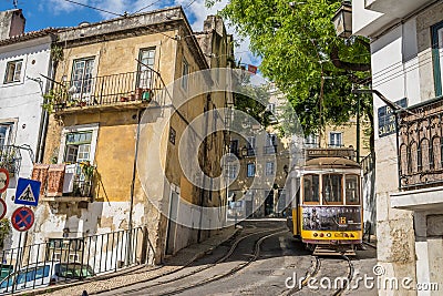 Very touristic place in the old part of Lisbon, with a traditional tram passing by in the city of Lisbon, Portugal. Editorial Stock Photo